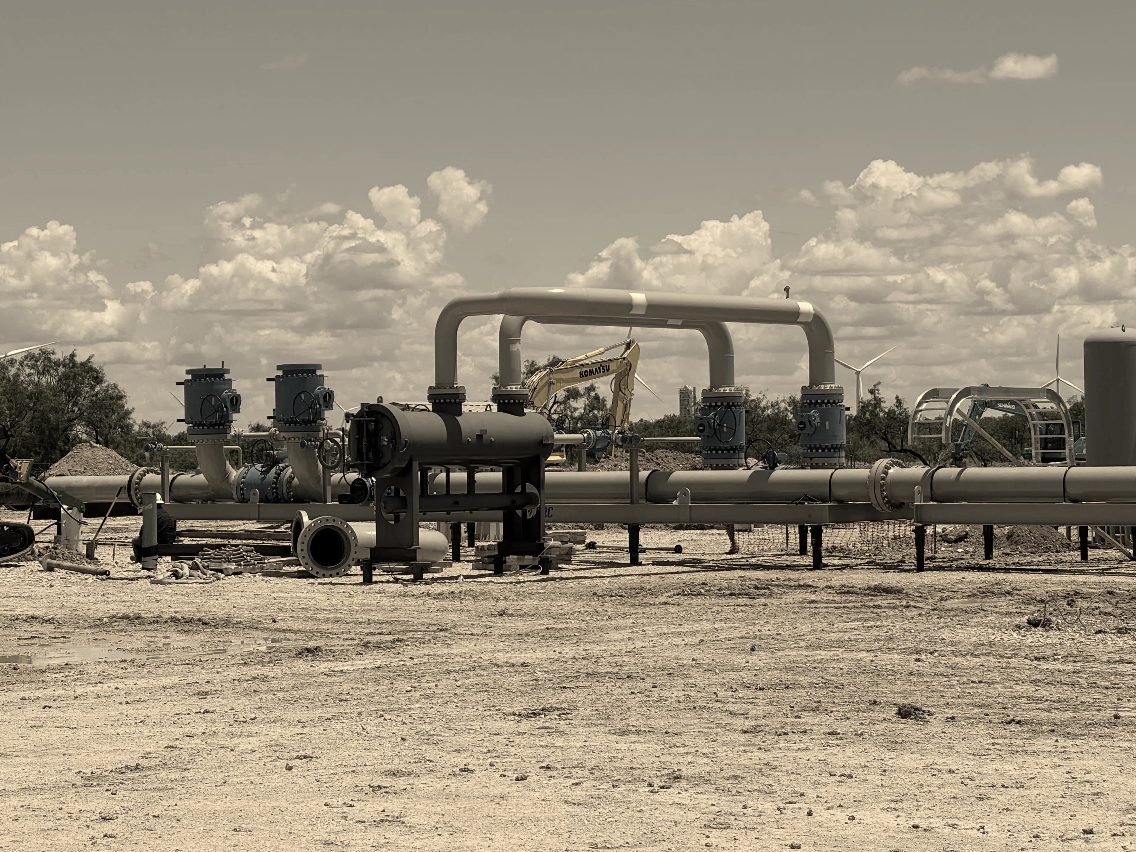 An above-ground pipeline run with valve assemblies and a pipe header loop at an outdoor installation